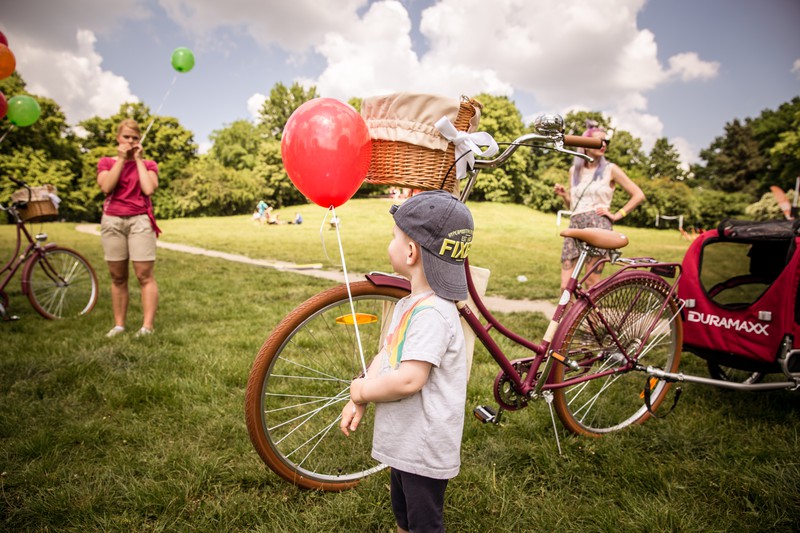 niños en bicicleta con globo en el parque